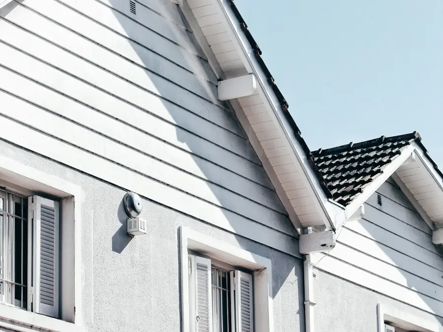 Fachada de vivienda con revestimiento y aleros recién pintados de blanco